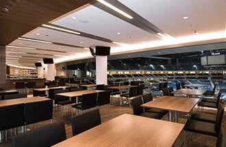 Tische im World Dinner Restaurant mit Blick auf den Arena Innenraum